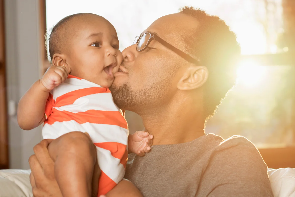 Father kissing baby son on cheek