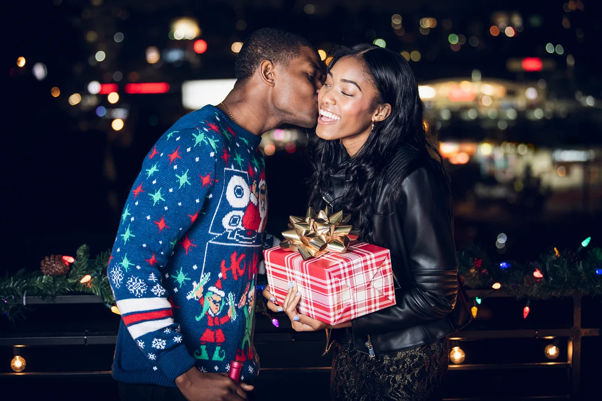 Young man giving girlfriend Christmas present