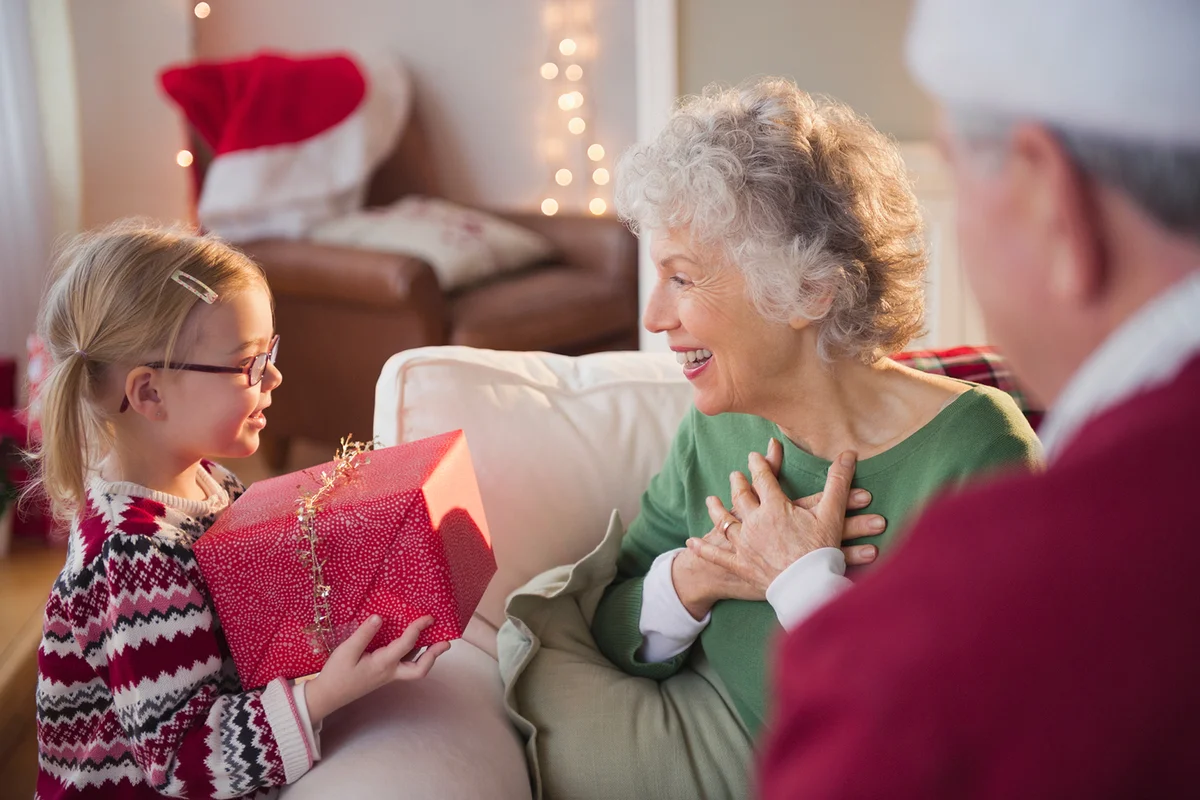 Granddaughter giving Christmas present to Grandma