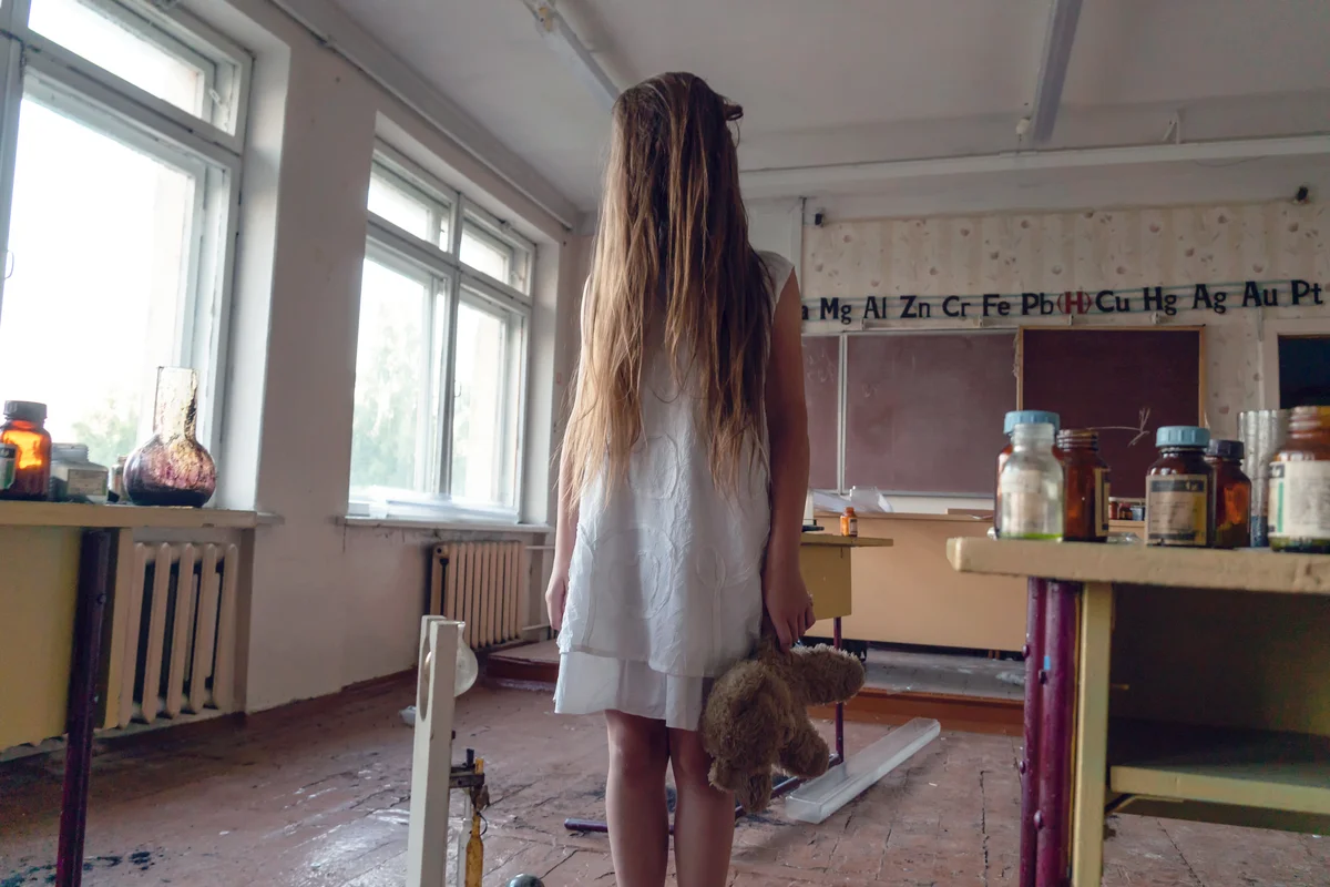 Girl in a white dress in an abandoned chemistry room