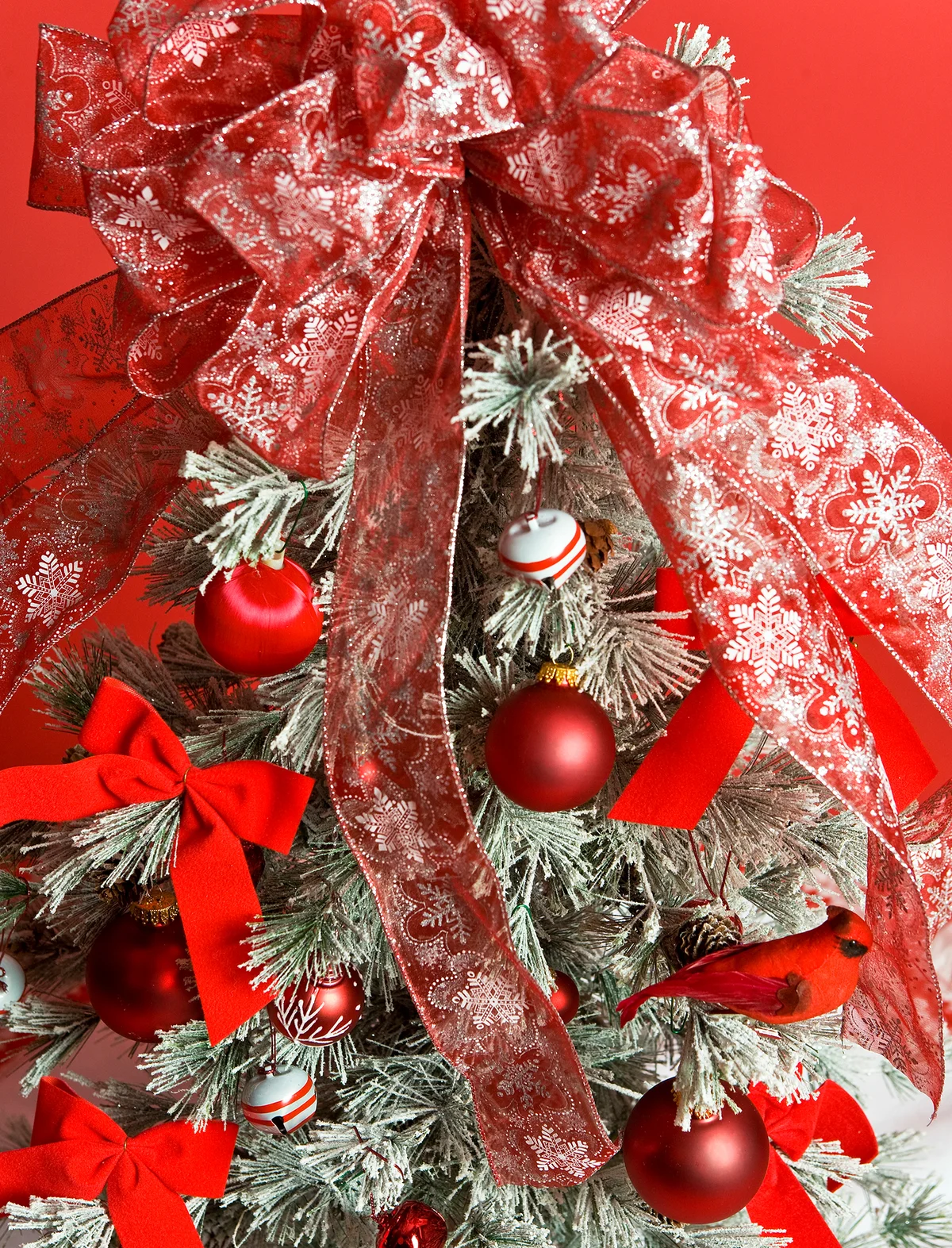 Red ornaments on a Christmas tree with a large bow on top