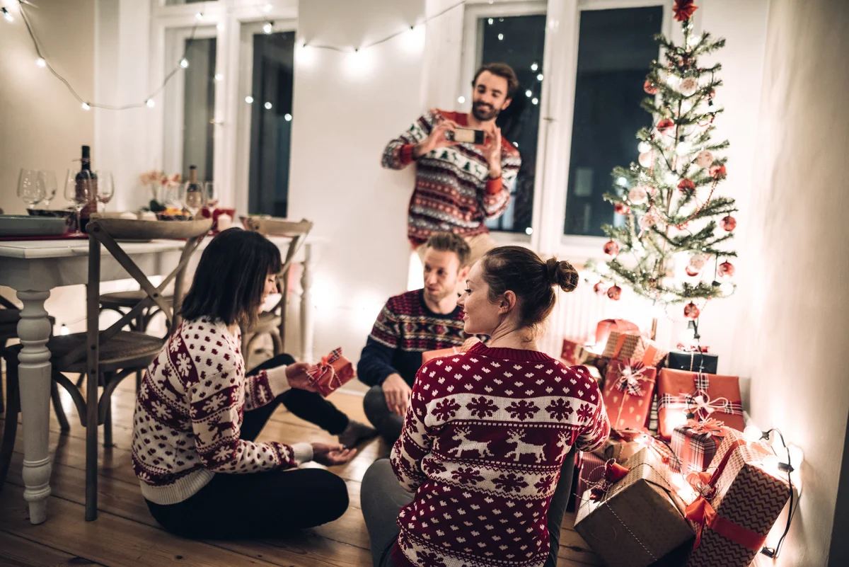 Friends exchanging christmas present at home