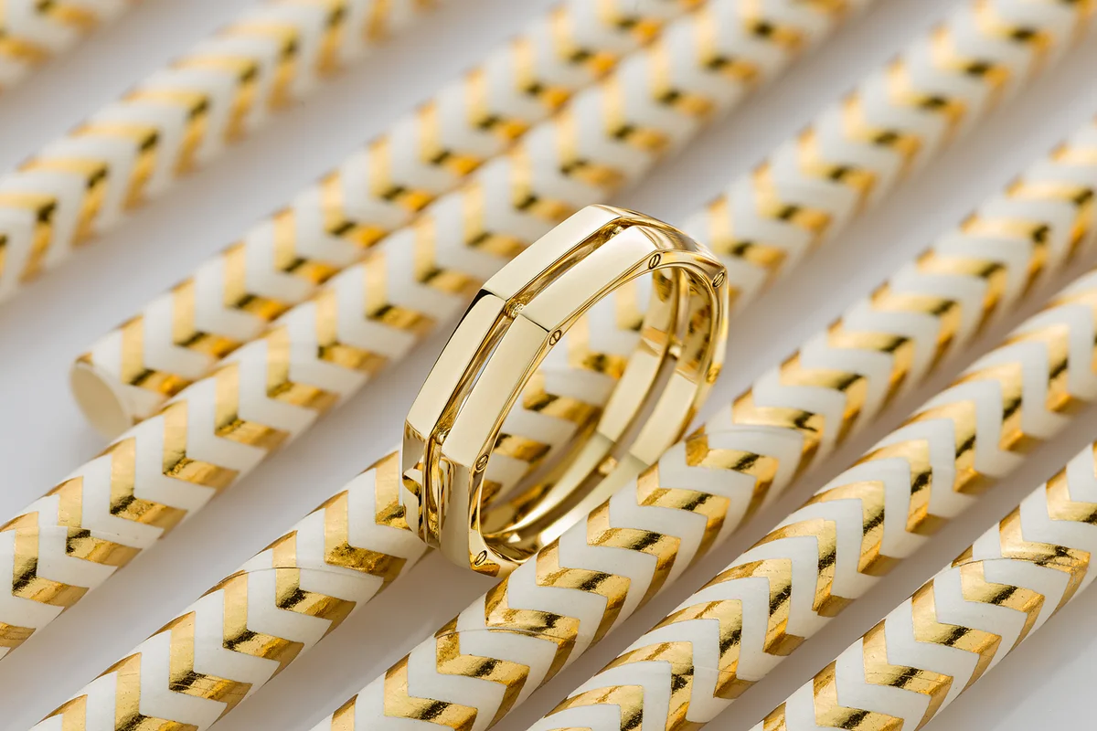 Geometric shape gold ring on golde glossy background