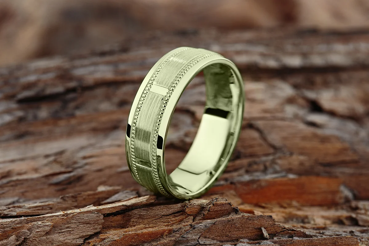 Modern green gold textured wedding ring on natural wood background