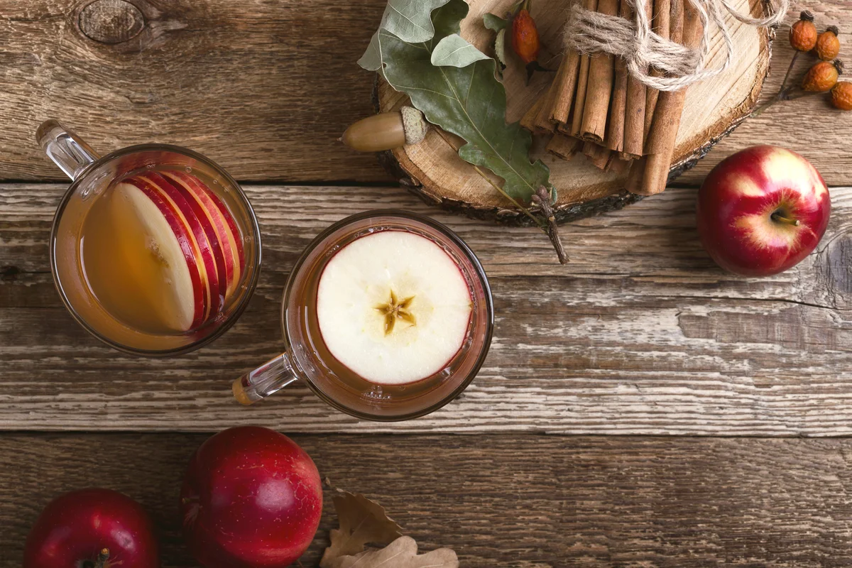 Hot cozy autumn and winter drinks with apple slices