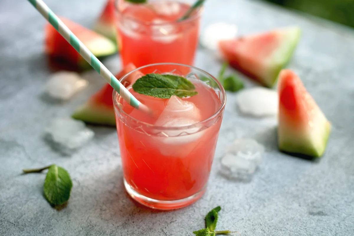 Watermelon martini with paper straws, mint leaves and ice