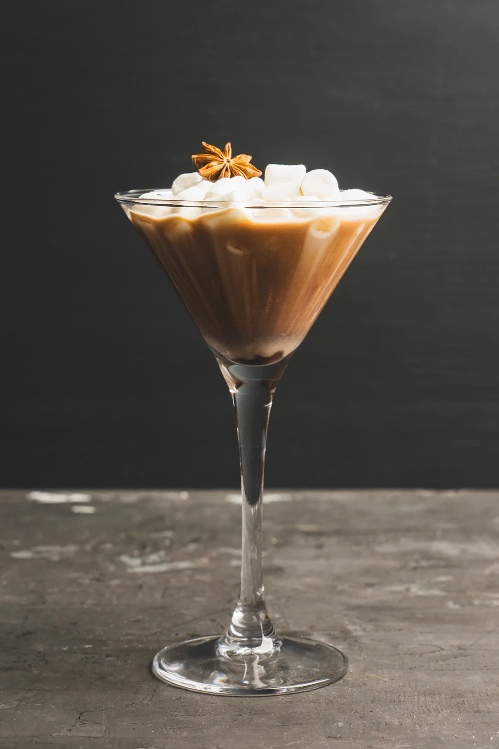 Chocolate martini with spices and marshmallow on the rustic background