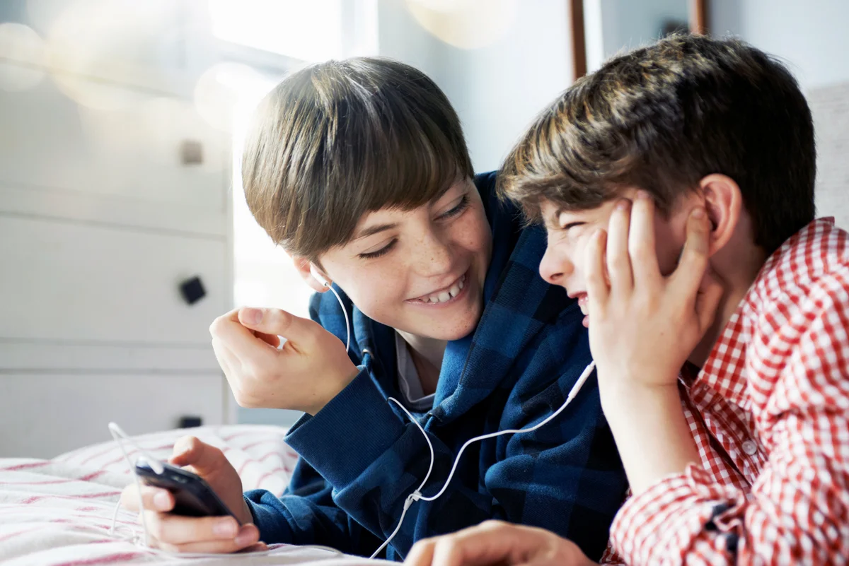 Brothers listing to music on mobile