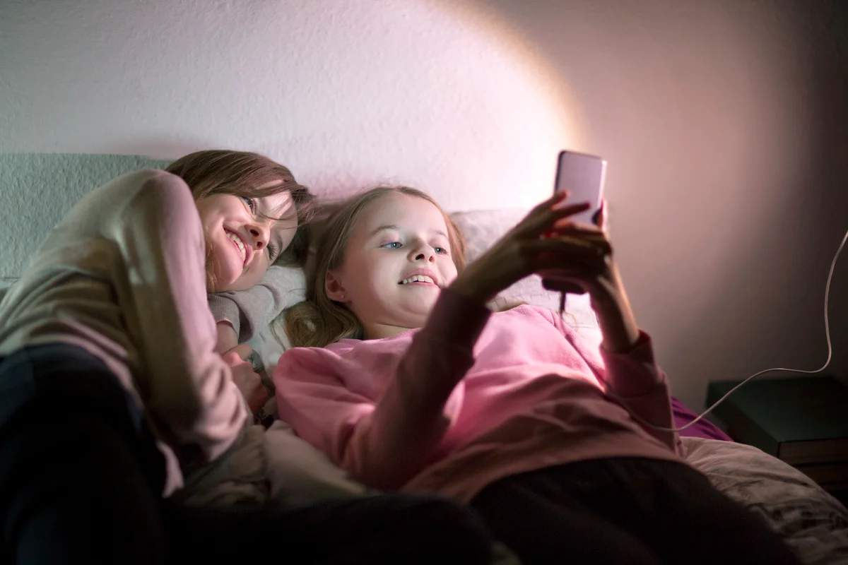 Two sisters using a mobile phone