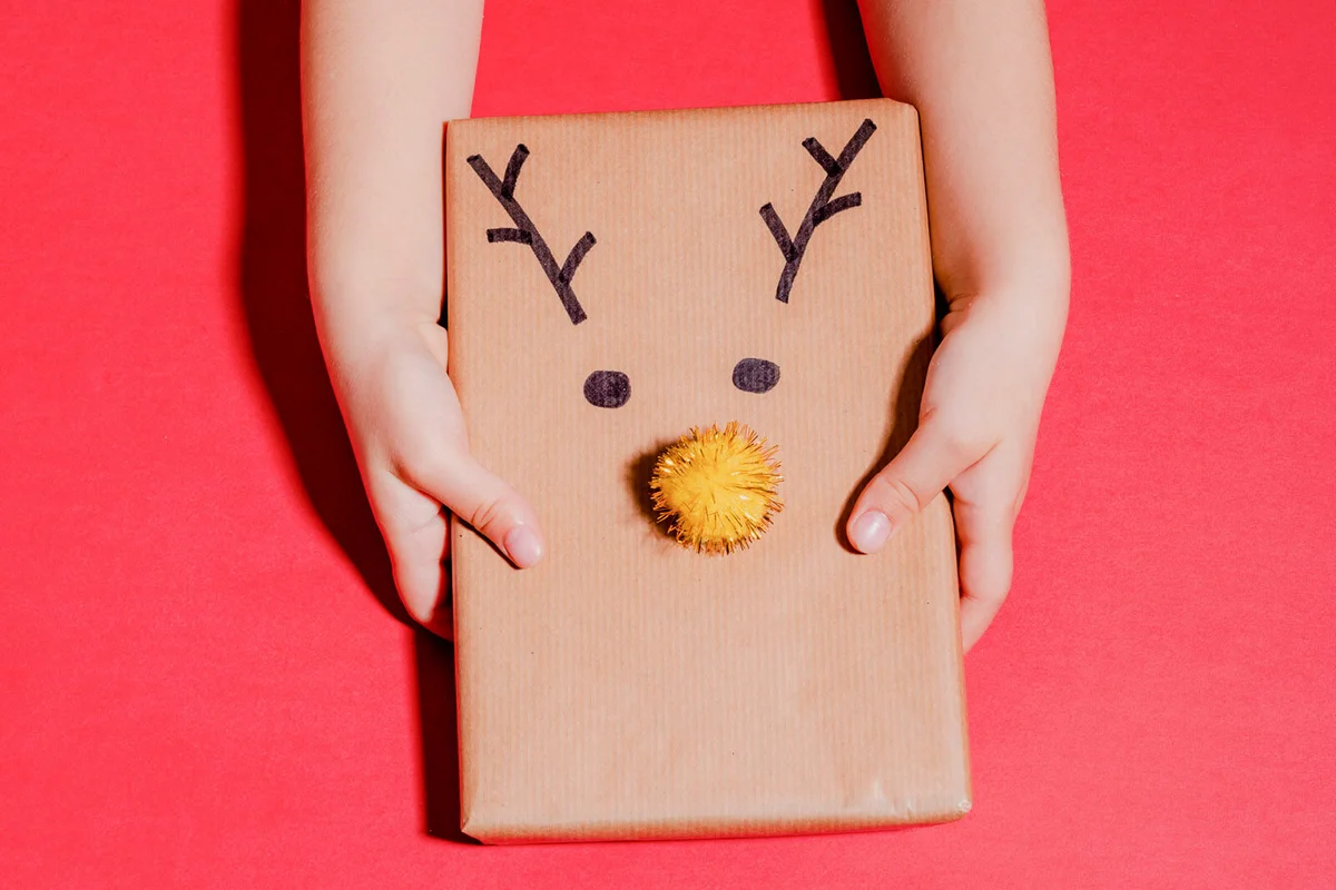 Christmas gift with Santa Claus reindeer handmade on red background
