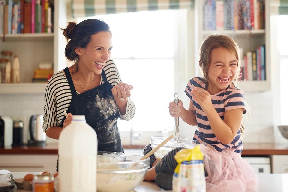little girl having fun baking with her mother in the kitchen