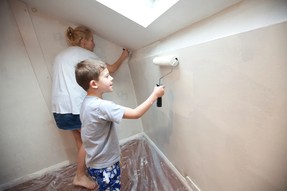 Mother and son decorating a bedroom.