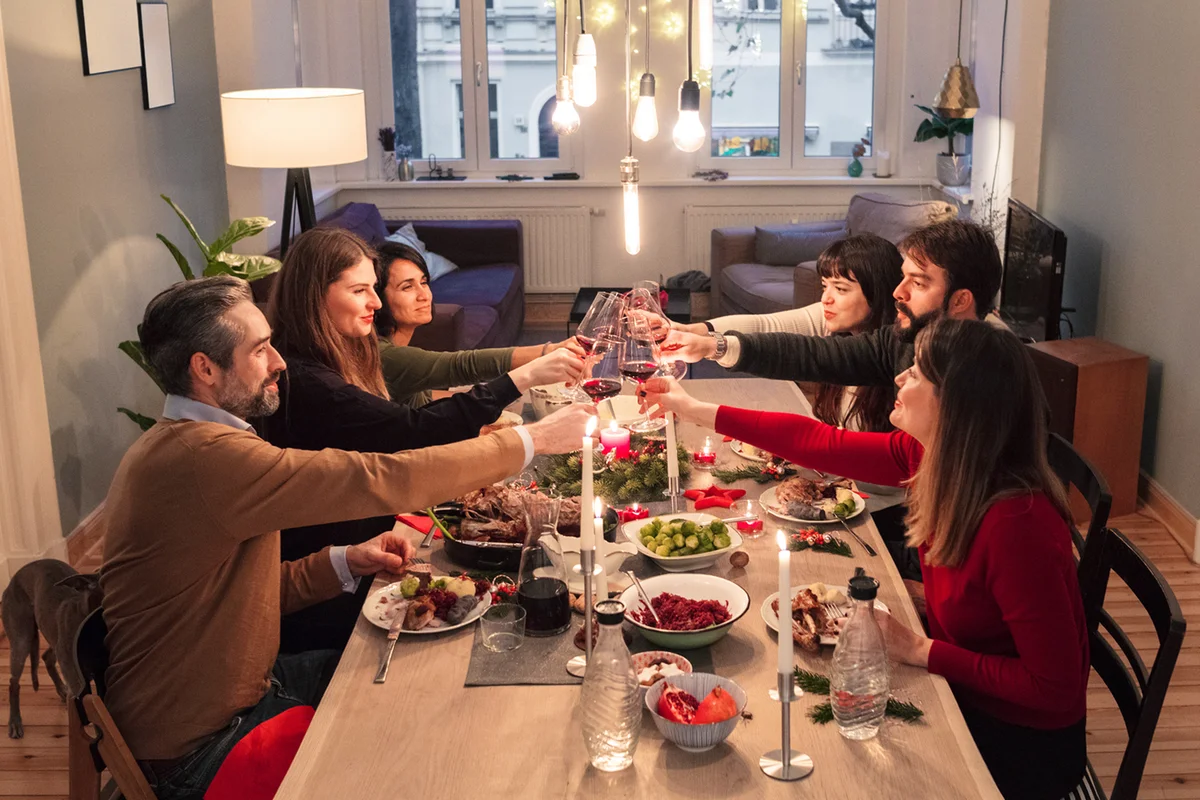friends toasting wine glasses at dining table during Christmas