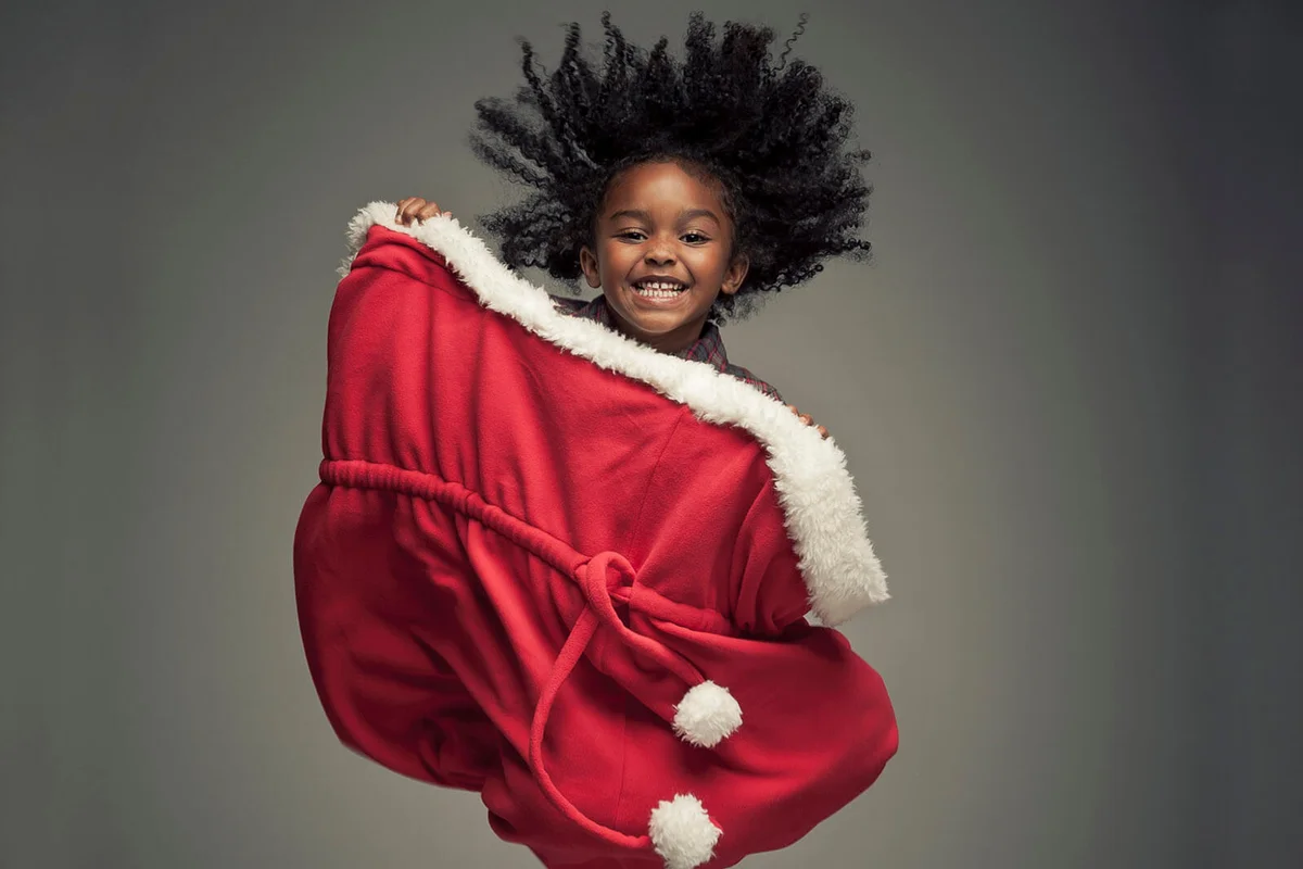 Young girl jumping in extra large Santa Bag