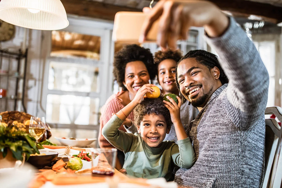 Happy family taking a selfie with cell phone in dining room