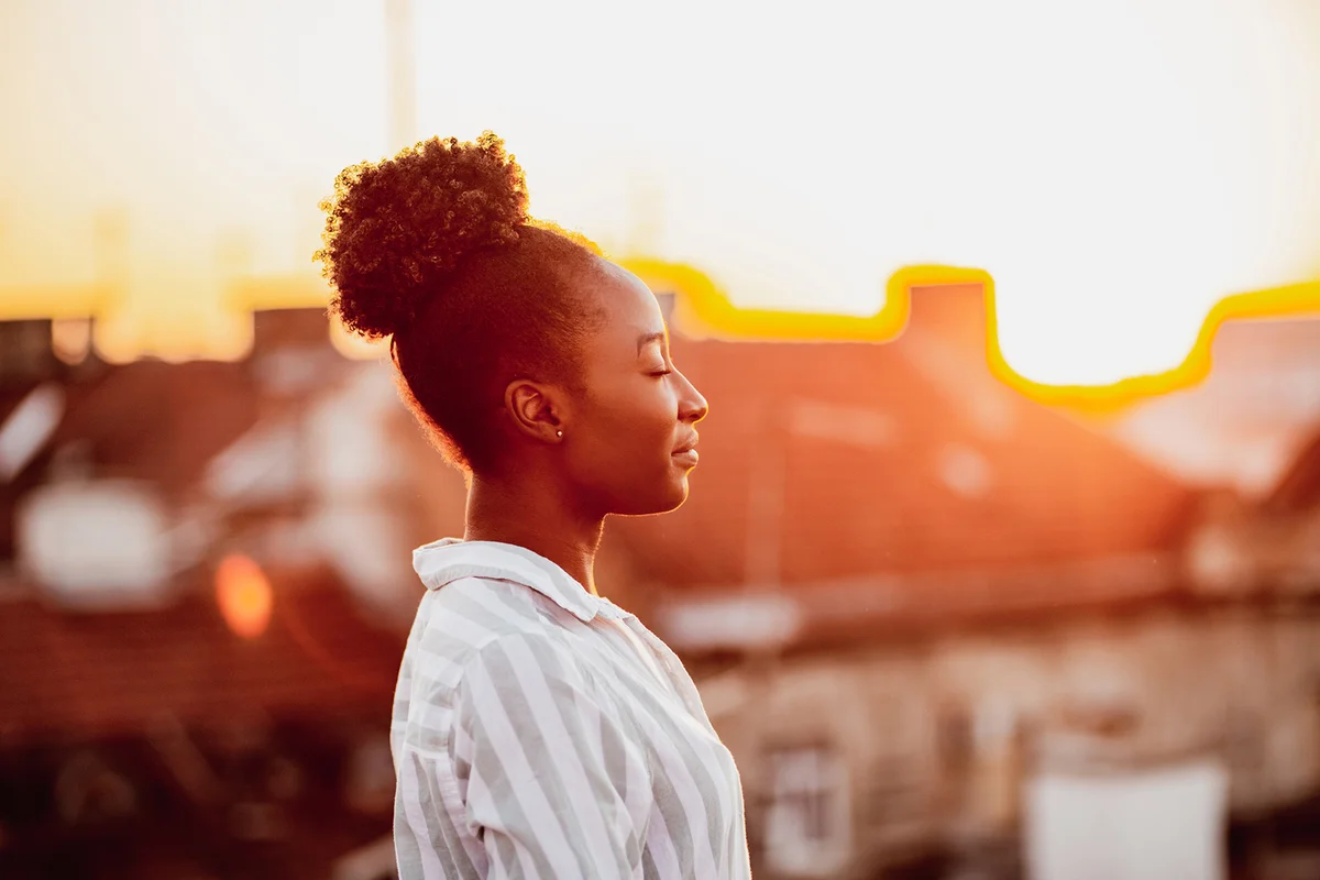 Young woman is meditating on the rooftop