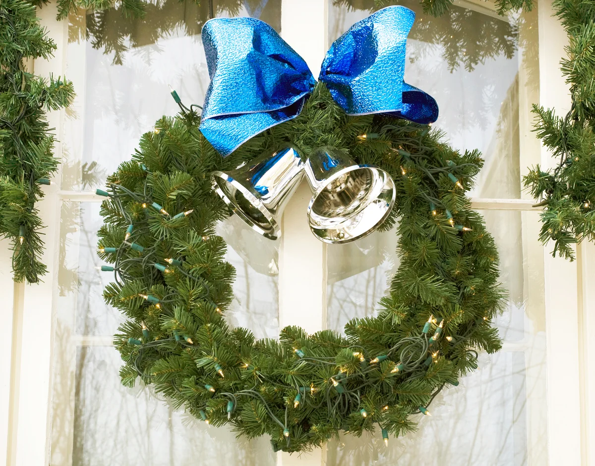 A Wreath With Silver Bells And A Blue Bow