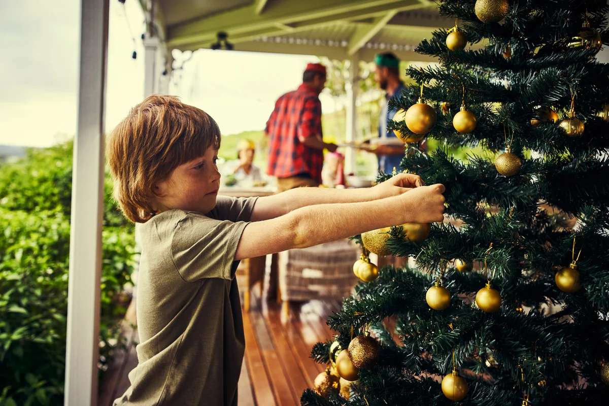 Little boy decorating a Christmas tree