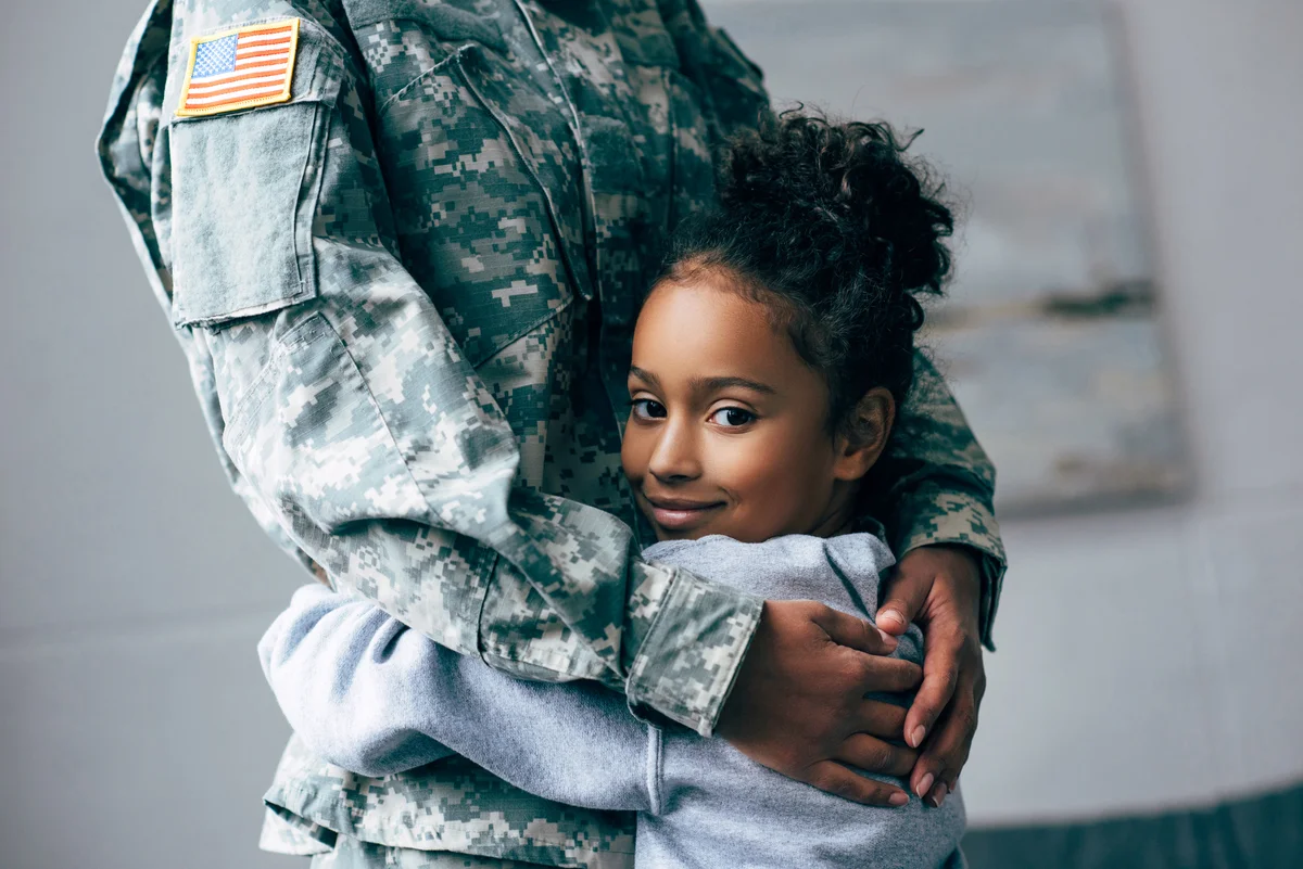 Daughter hugging soldier