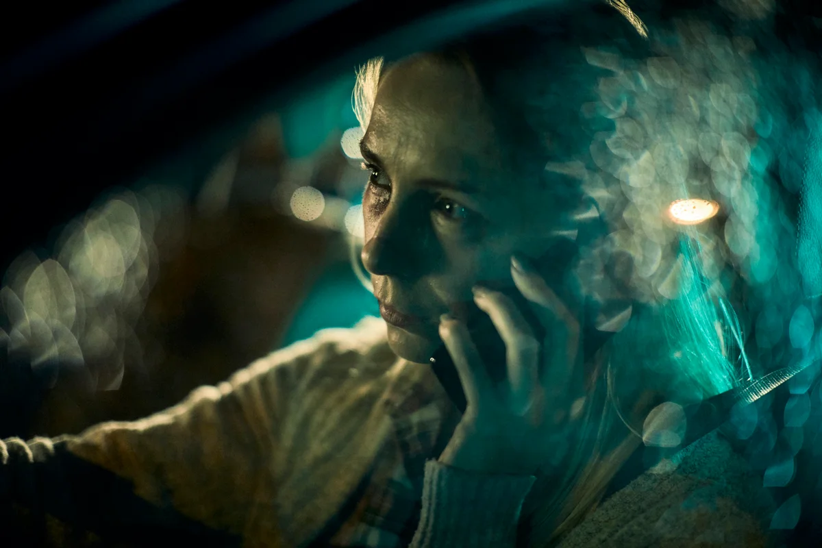 Scared woman driving and talking on the phone
