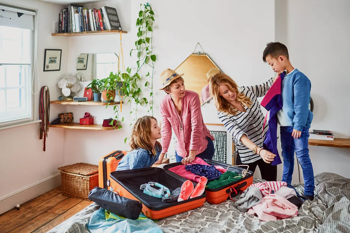 couple packing suitcases for holiday with children