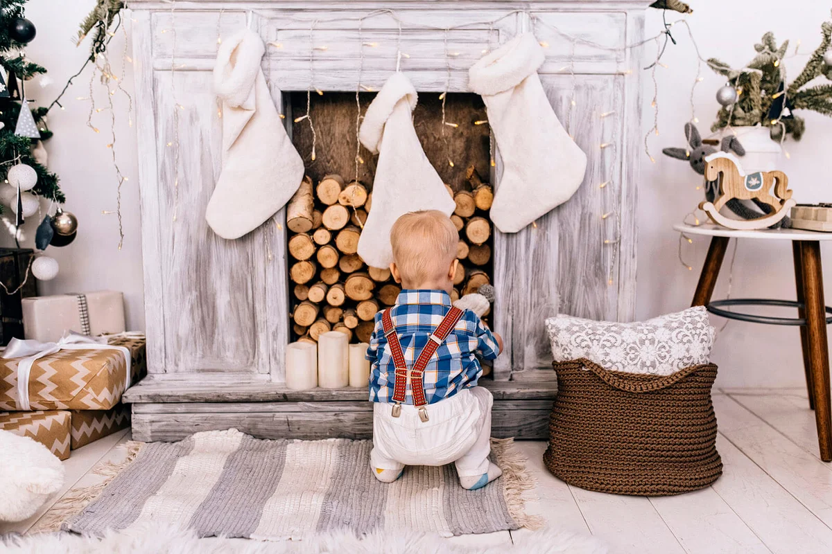 Baby boy crouching at fireplace during Christmas time