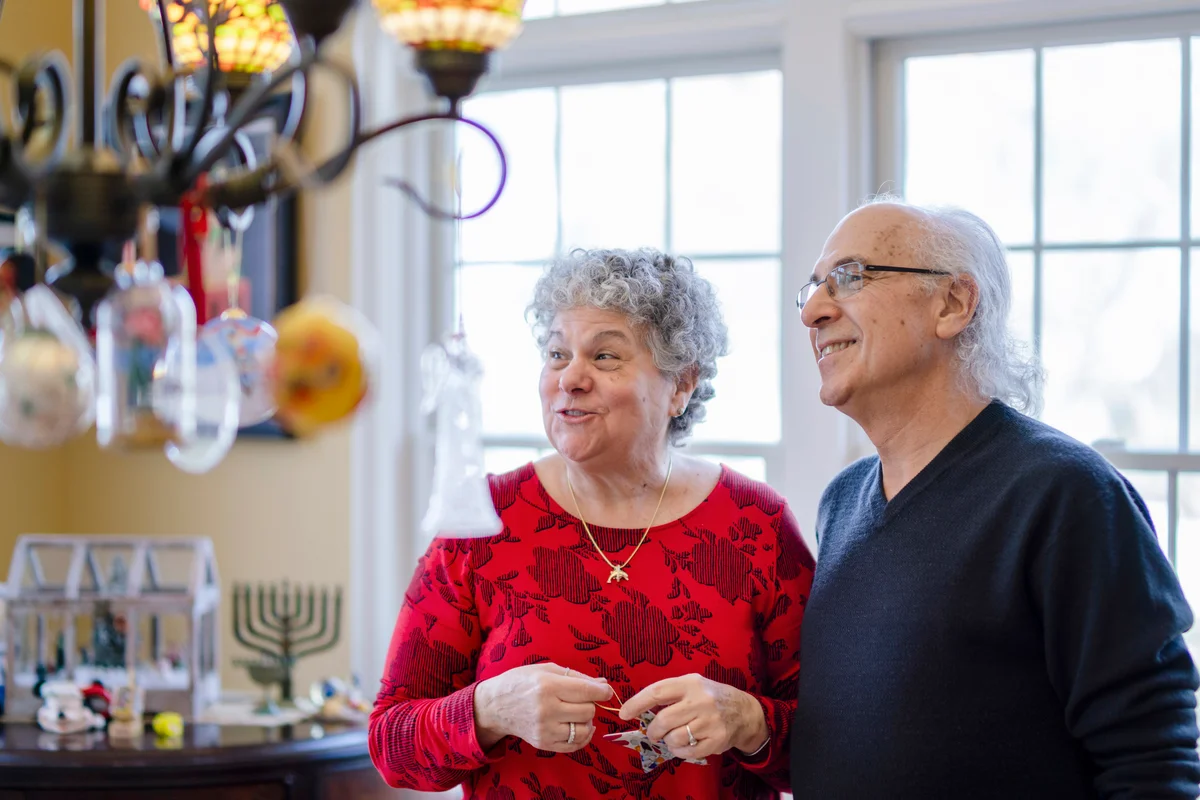 Senior couple decorating their house for the winter holidays, both Christmas and Hanukkah