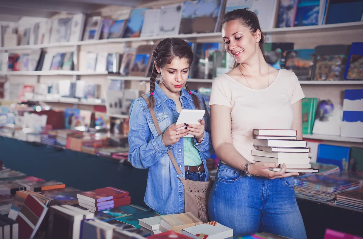 Teenager is buying books and searching information on tablet with her mom