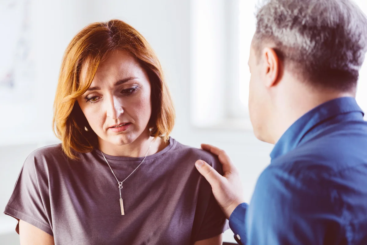Man consoling depressed woman