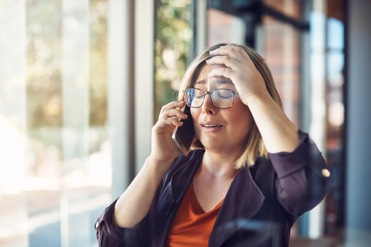 Woman looking distraught while talking on a mobile phone
