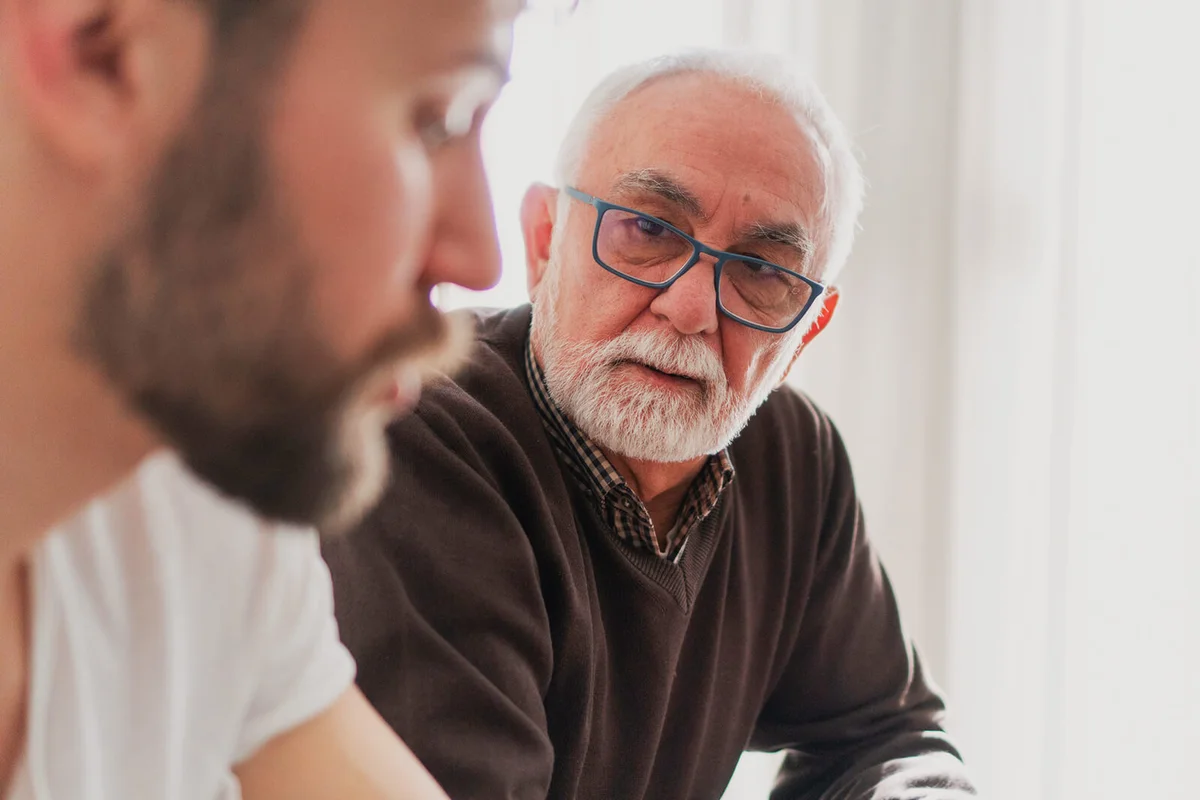 man is talking with his son in the living room