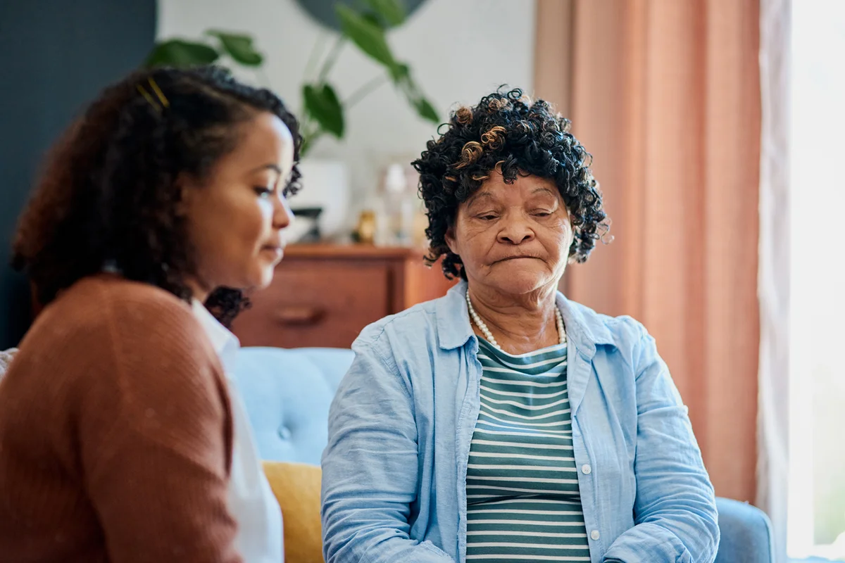 Woman sitting with her daughter on the sofa at home and not talking