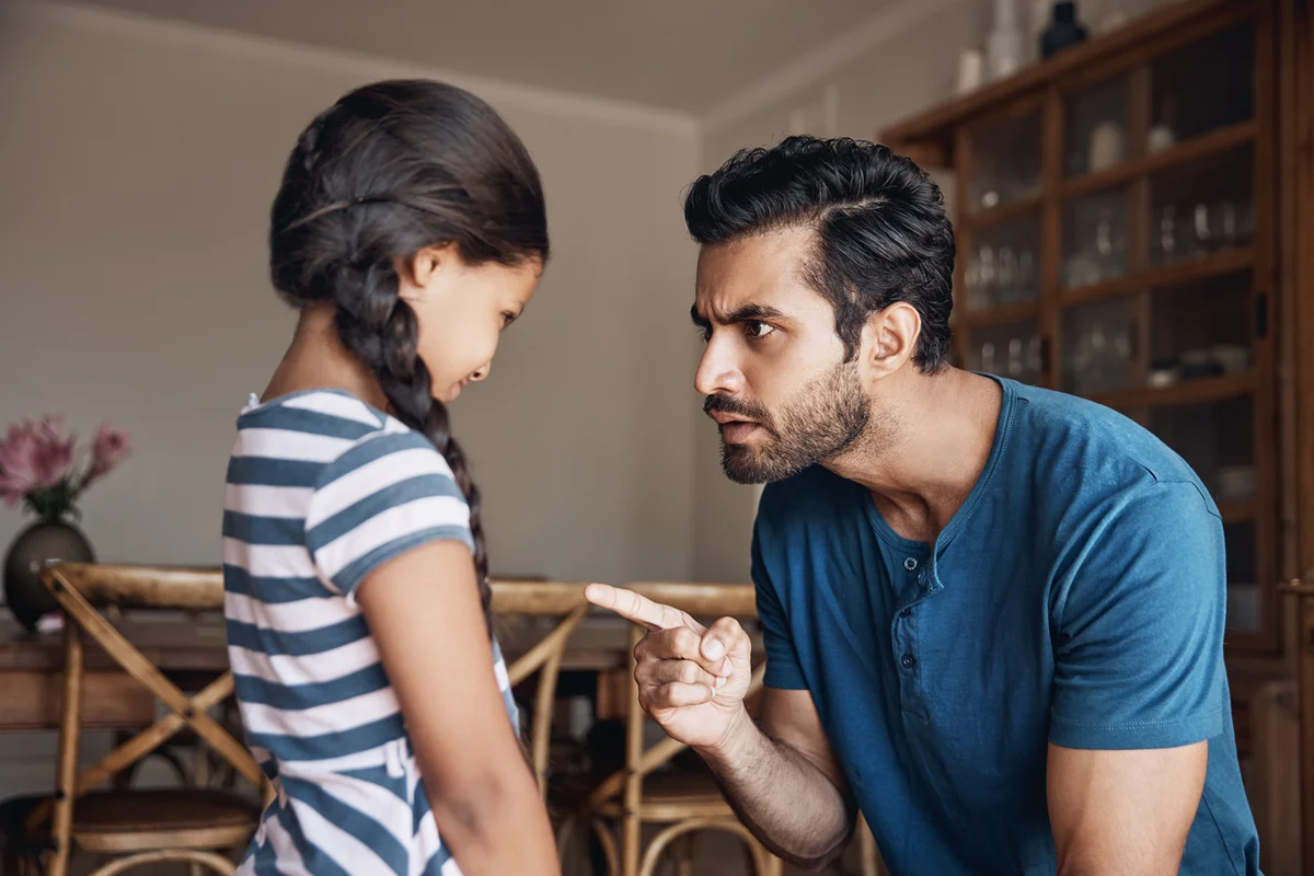father disciplining his daughter at home