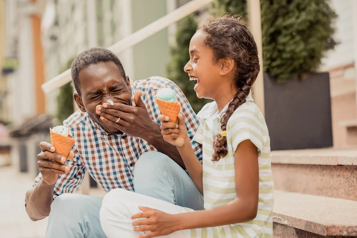 Charming teenager laughing at funny situation, spending time with her daddy