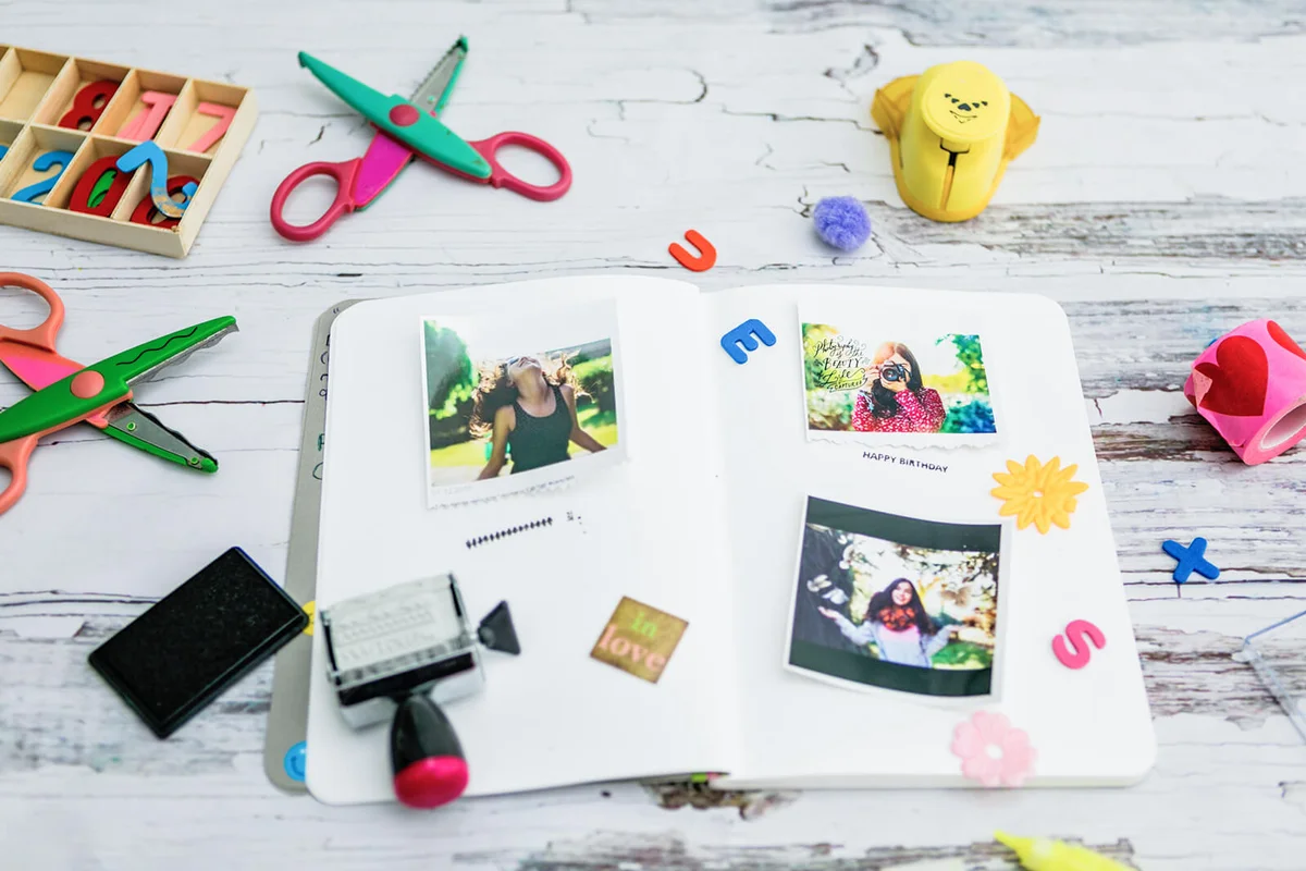 Assortment of scrapbooking tools including colored paper, pens, and scissors
