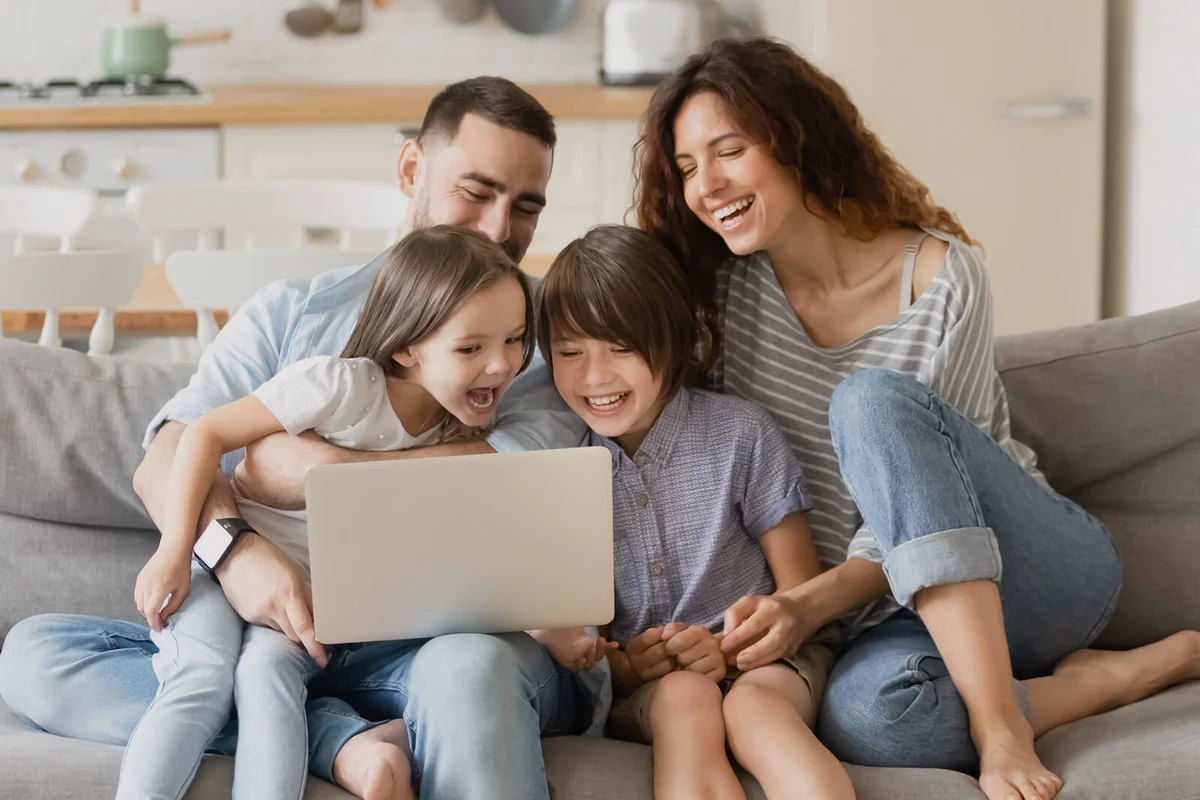 happy parents with daughter and son using laptop