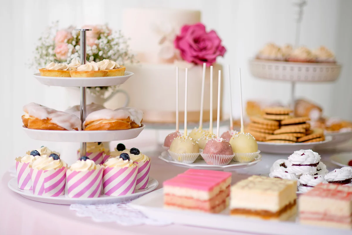 Table with cakes, cupcakes, cookies and cakepops.
