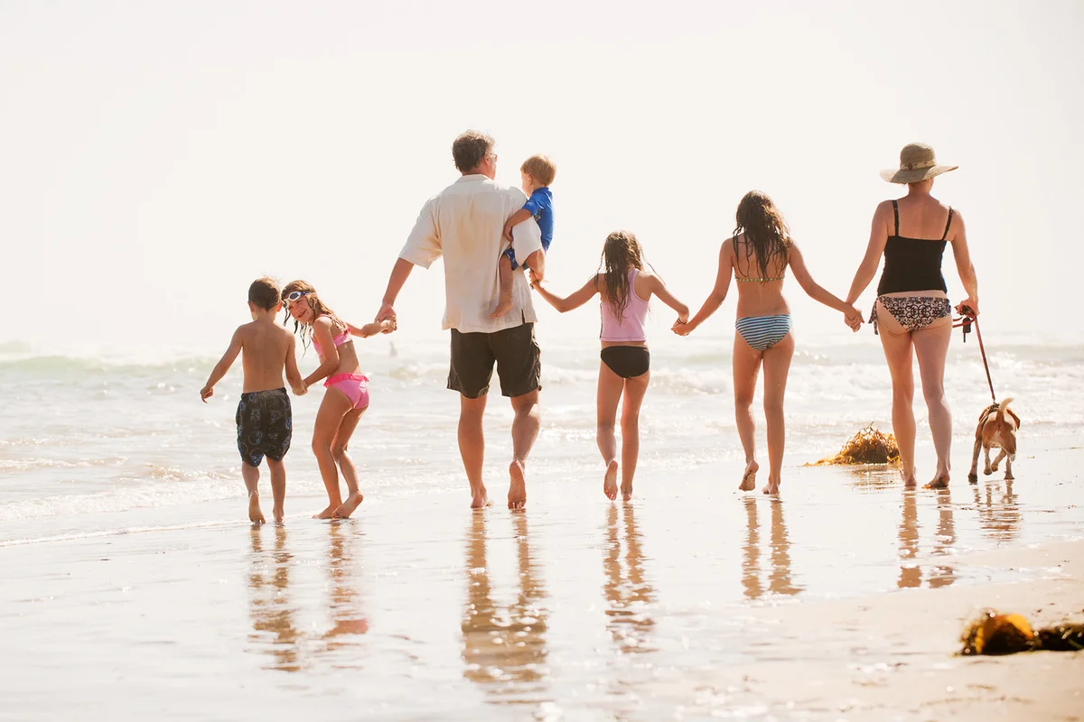 Family of seven walks on the beach