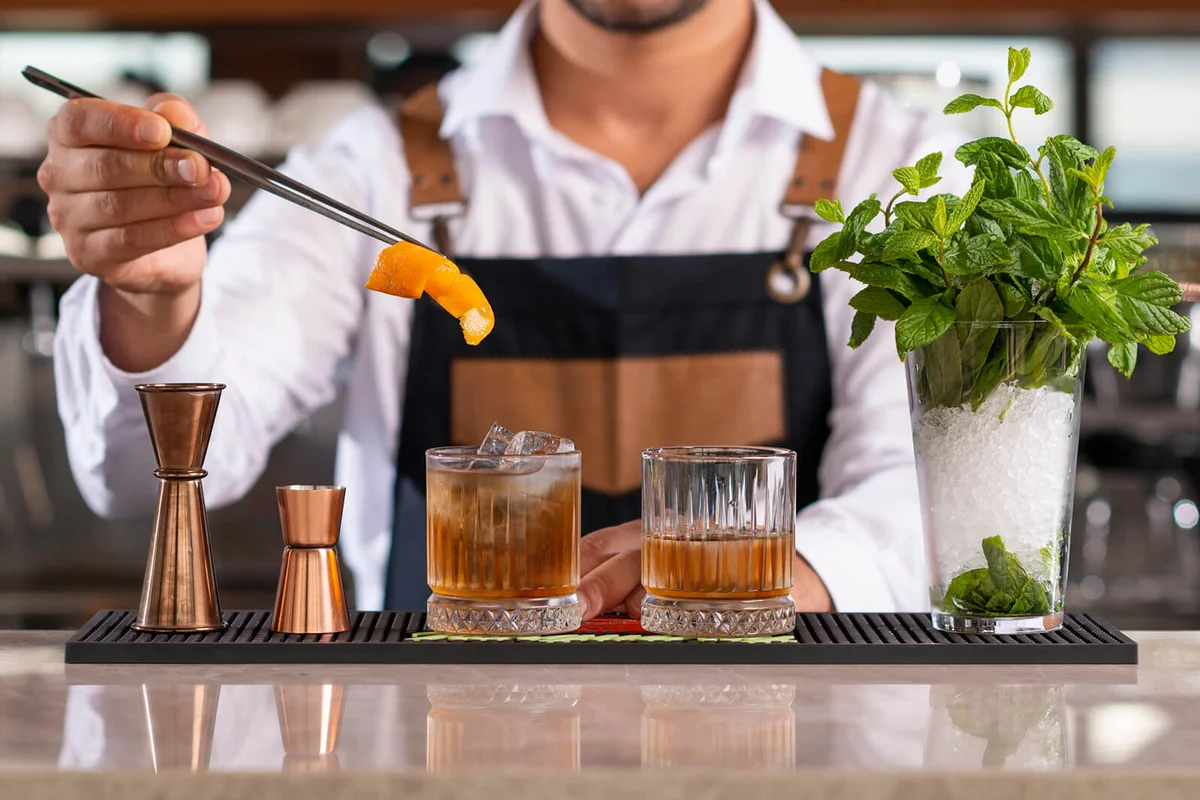 Bartender adding lemon peel in a drink