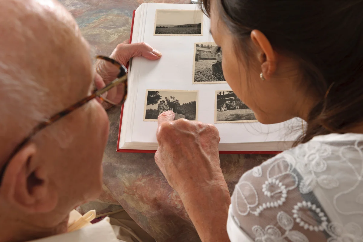 Grandfather and granddaughter looking photo album