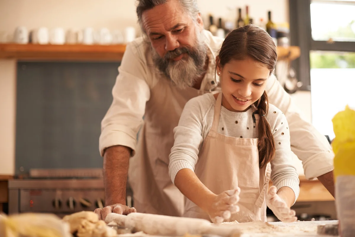 Grandfather and granddaughter baking