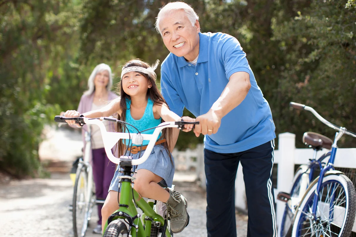 Grandfather granddaughter ride bicycle