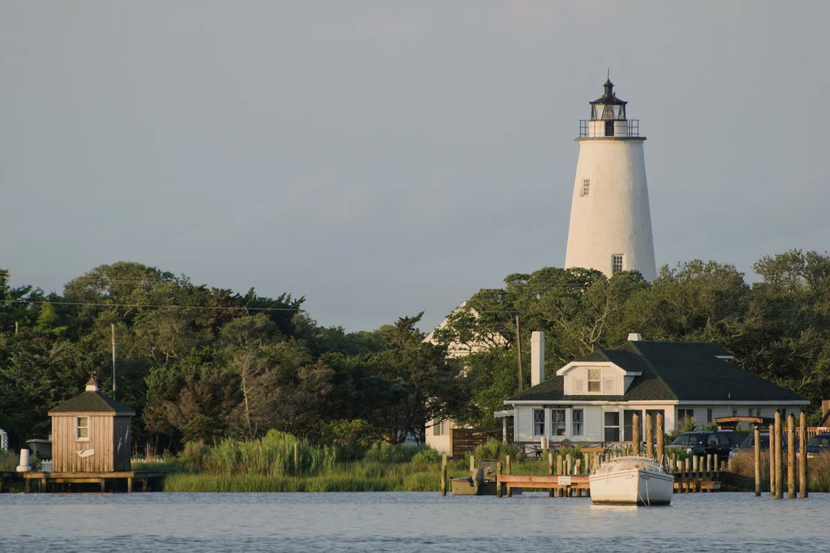 Lighthouse By Building Against Sky