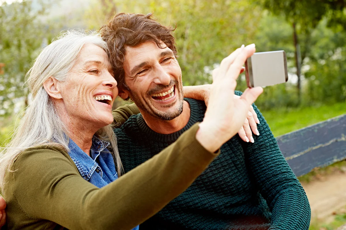 Cheerful mother and son taking selfie in park