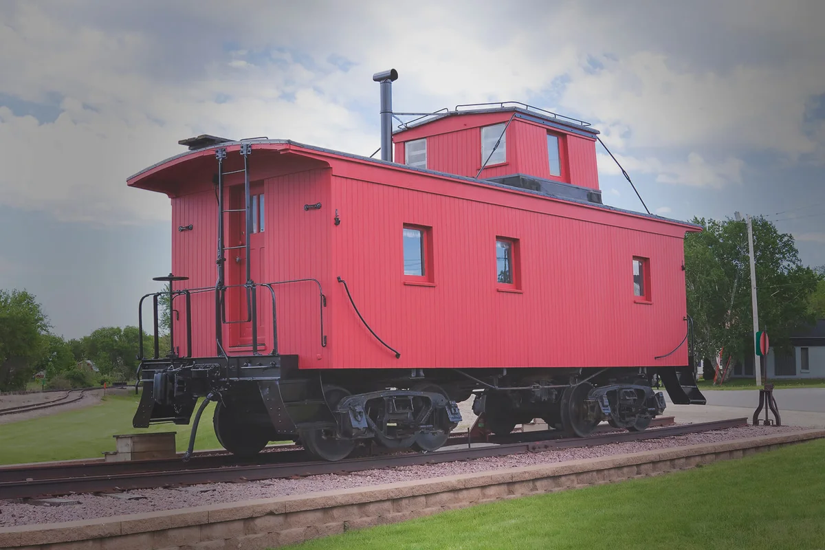 An old wooden red caboose on display