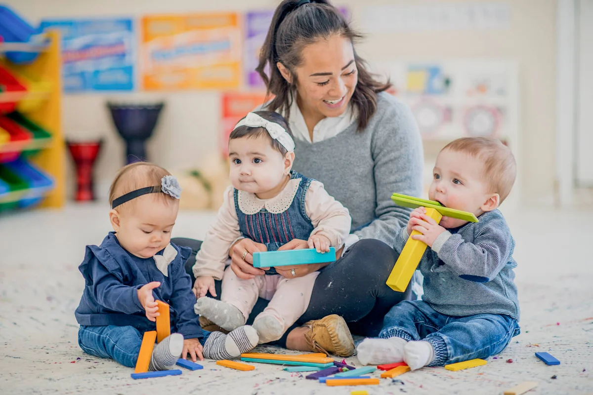 Teacher playing with babies