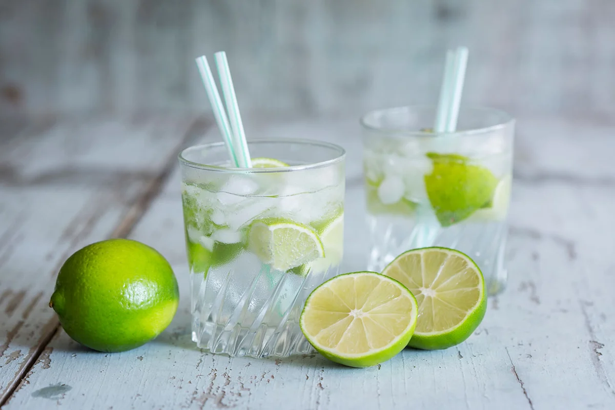 Glasses of infused water with lime and ice cubes