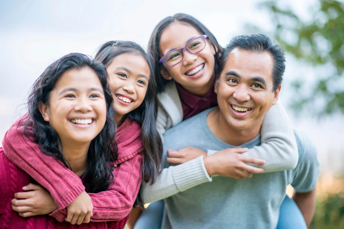 A small Filipino family of four spend some time close together while outside