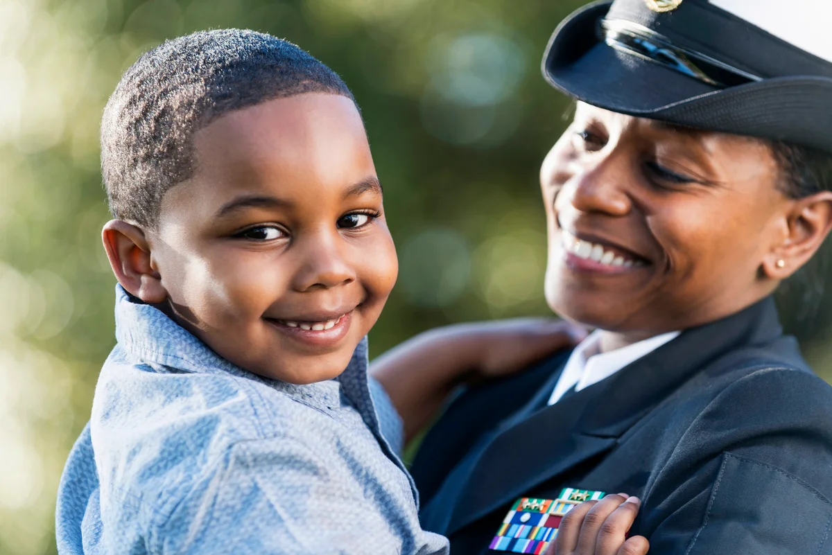 Woman in uniform holding kid