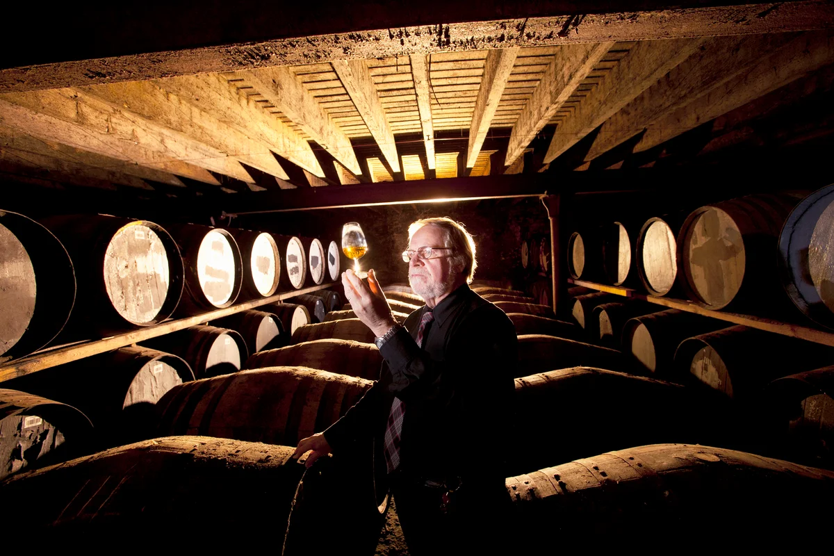 Worker testing whisky in distillery